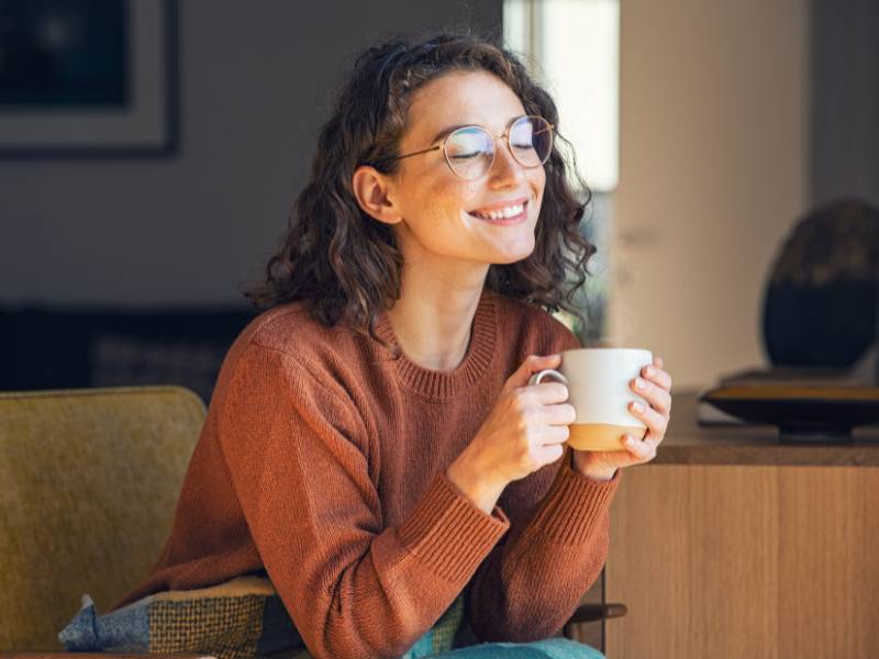 Frau mit Tasse in der Hand lächelt